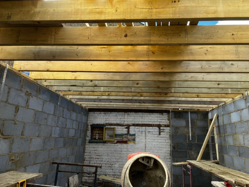 Internal blockwork and timber roof joists during extension construction