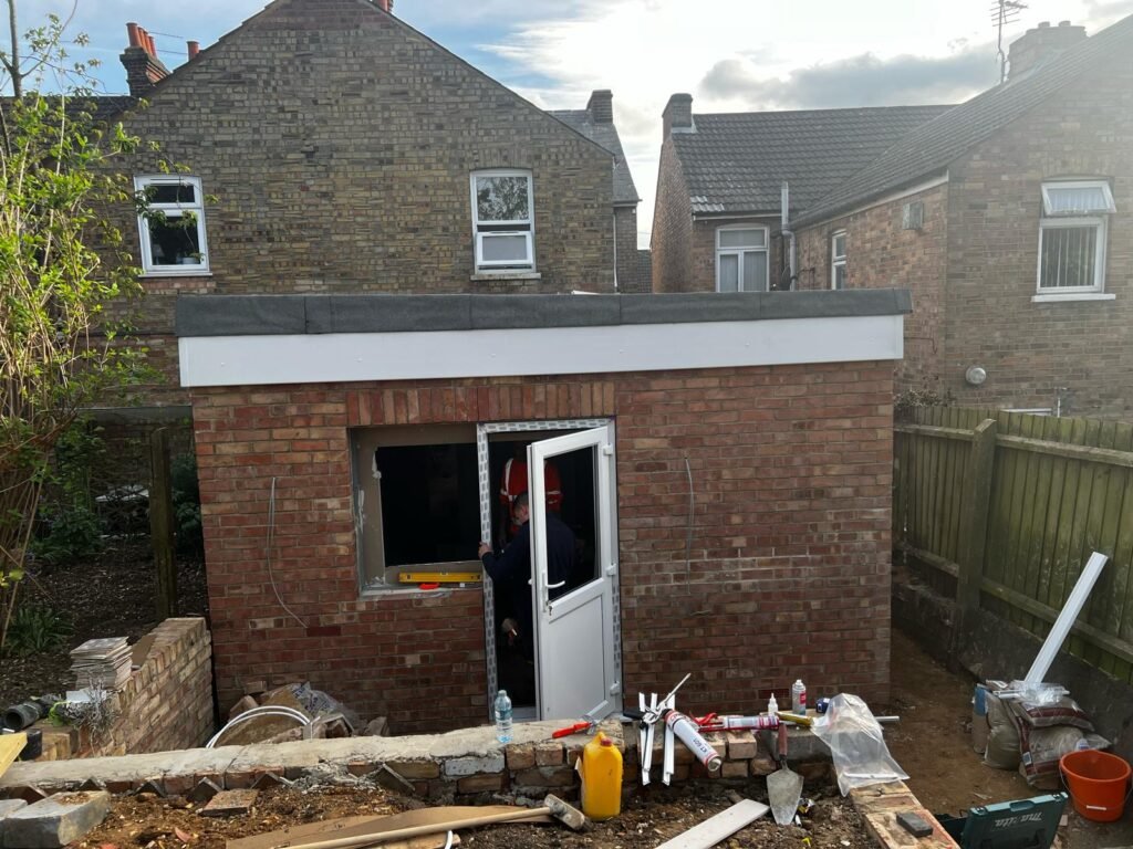Rear brick extension with external doors and windows being installed